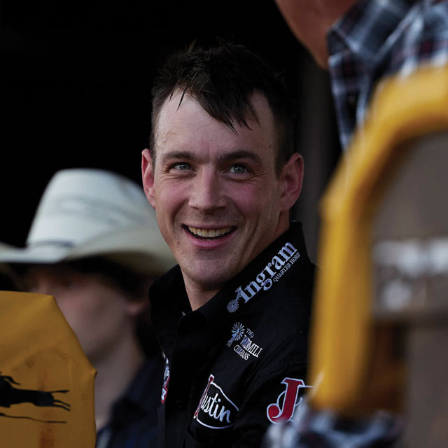 Tim O'Connell looking at another man smiling and wearing a black shirt.